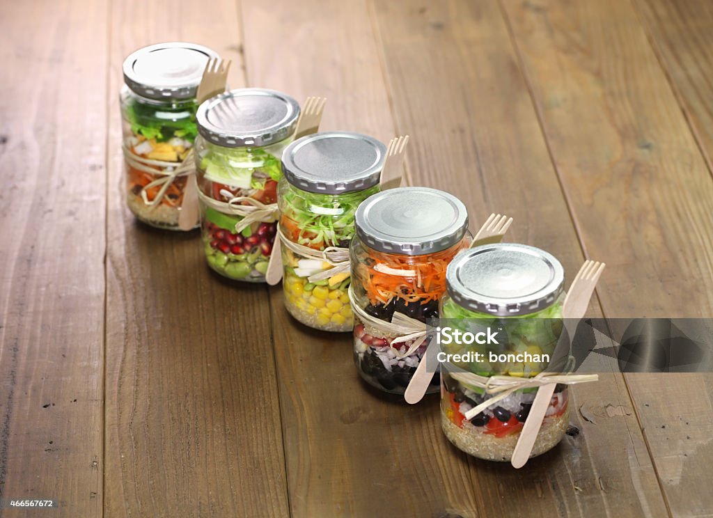 Five jars of salad tied with string with a fork attached homemade healthy salad in glass jar Bottle Stock Photo