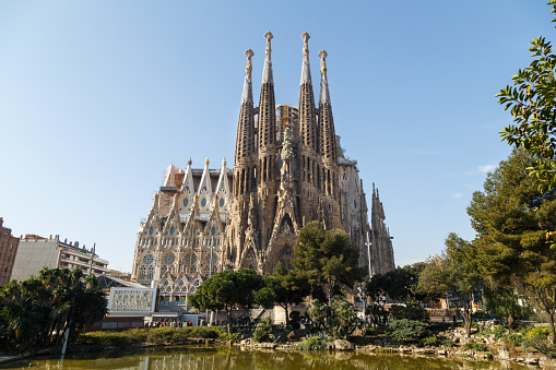 Sagrada Familia is one of the iconic symbols of Barcelona. It is a Roman Catholic church which construction has started in 1882 by the famous Catalan architect Antoni Gaudi and it is still under construction.  At the photo is a view of the Nativity facade of Sagrada Familia from Placa de Gaudi.
