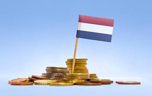 Flag of Netherlands in a mixed stack of european coins and a blue background.(series)