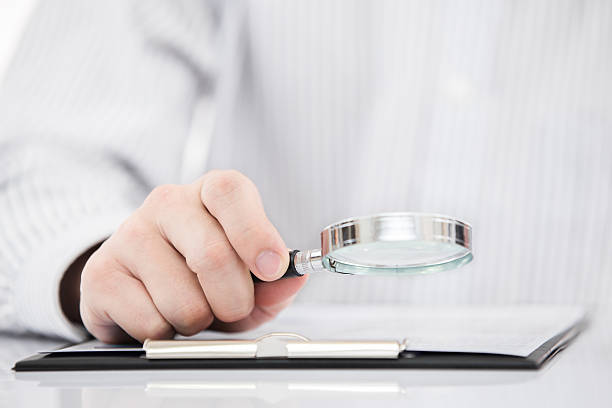 istock Businessman looking through a magnifying glass 466574505