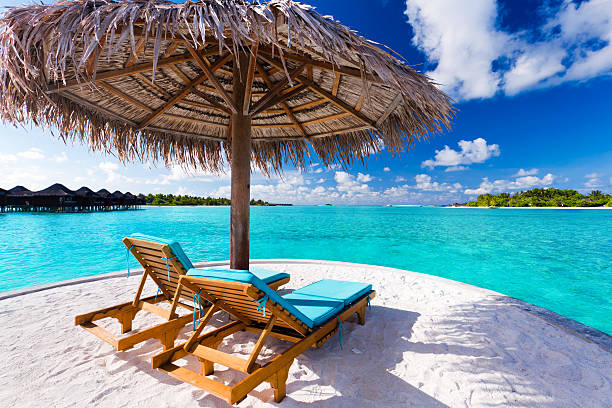 istock Two chairs and umbrella on tropical beach 466576971