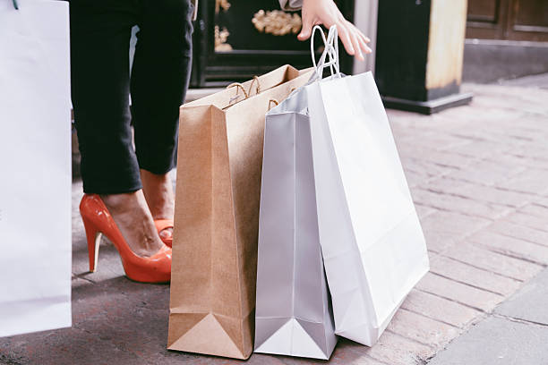 istock Young woman looking through shopping bags 466580850