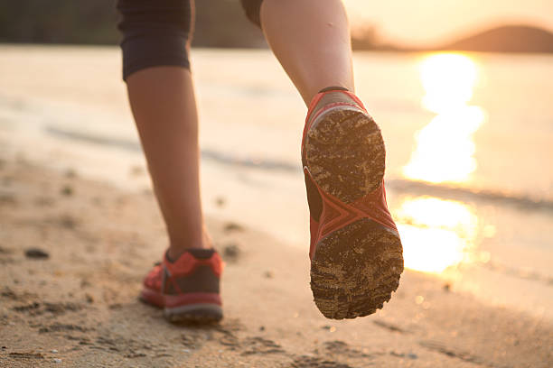 istock Woman running on beach at sunset-Feet 466580884