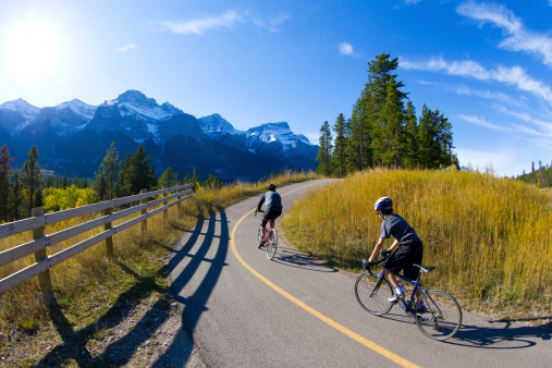 A father and son ride road bicycles on the Legacy Trail in Banff National Park, Alberta, Canada.