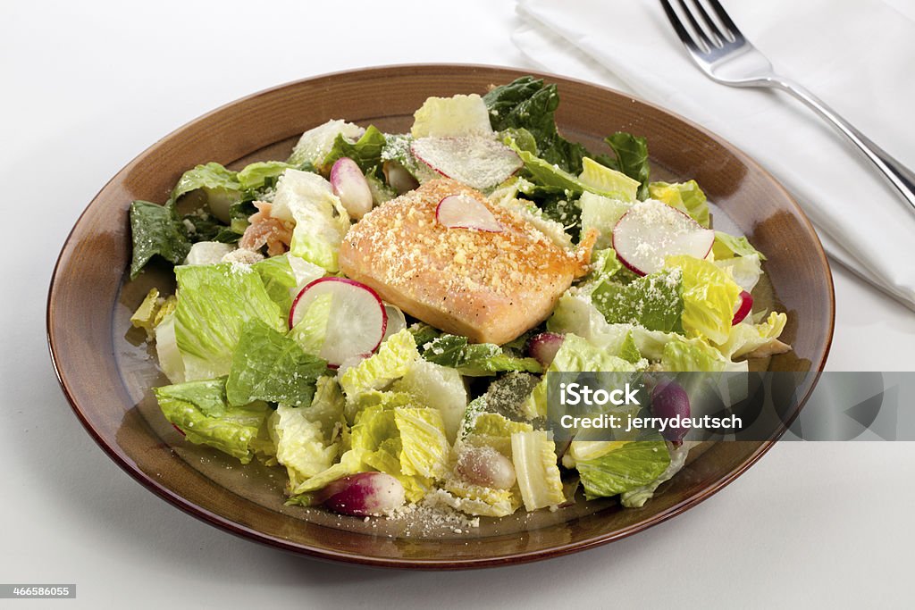Salmon Salad with Fork and Napkin A brown bowl of salmon salad with romaine lettuce, radishes, baby radishes, parmesan cheese and dressing. Cheese Stock Photo