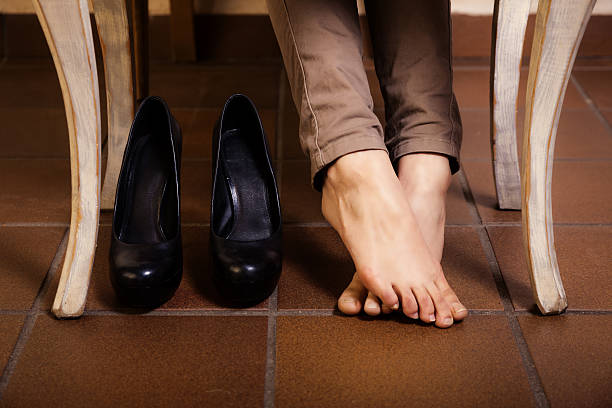 istock Bare female feet under the vintage table. 466596072