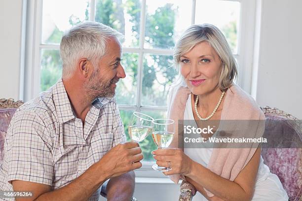 Happy Mature Couple With Wine Glasses At Home Stock Photo - Download Image Now - 2015, 50-54 Years, 50-59 Years