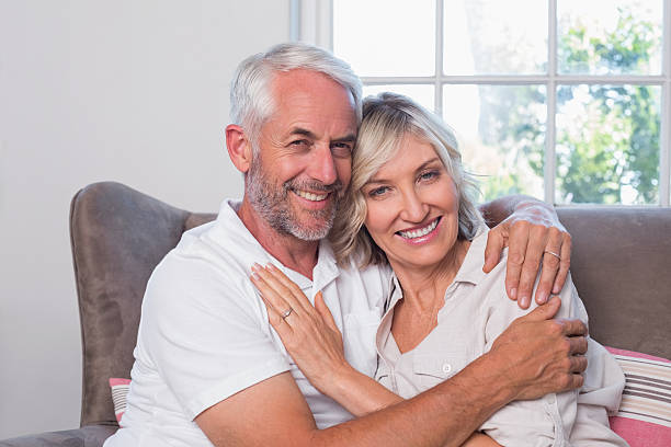 istock Mature man embracing woman on couch 466596384