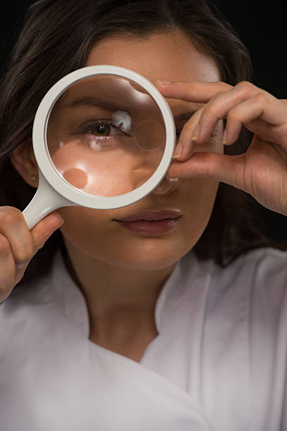 医師から見た拡大鏡 - low scale magnification glass women holding ストックフォトと画像