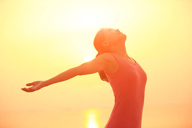 istock cheering woman open arms under sunrise on beach 466597843
