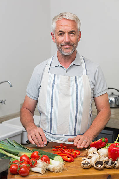 istock Portrait of a mature man chopping vegetables in kitchen 466598546