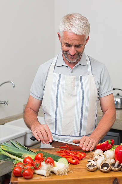 istock Mature man chopping vegetables in kitchen 466598562