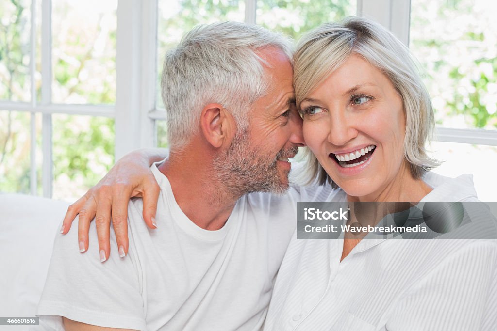 Loving mature couple with arm around Loving happy mature couple with arm around at home 2015 Stock Photo