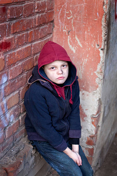 istock homeless boy leaned against the wall 466601683