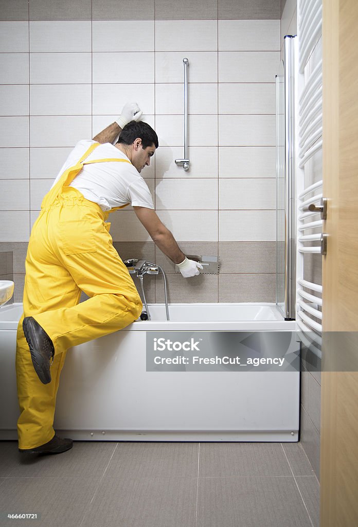 Bathroom tiling Man installing ceramic tiles Bathroom Stock Photo