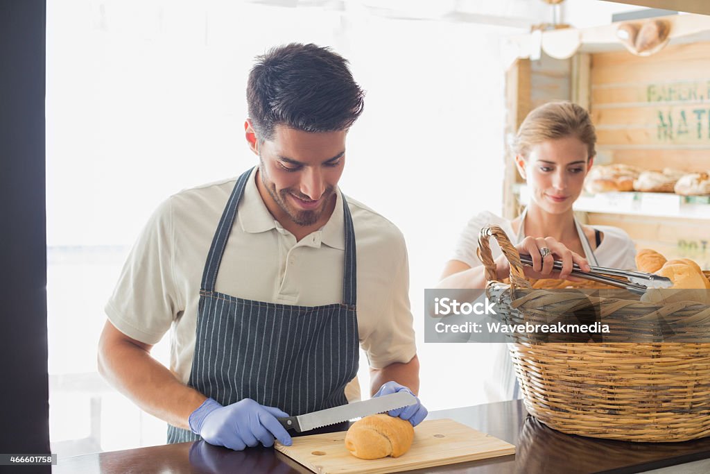 Young waiter with croissant at the coffee shop counter Portrait of a smiling young waiter with croissant at the coffee shop counter 20-24 Years Stock Photo
