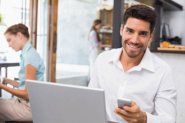 istock Man using laptop and mobile phone in coffee shop 466602668