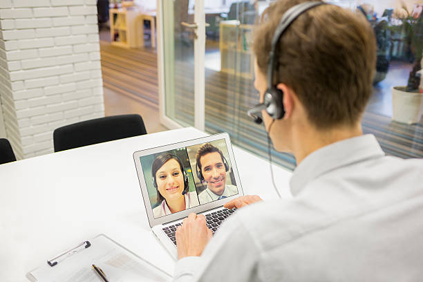 empresário no escritório no videoconferência com fones de ouvido, skype - skype - fotografias e filmes do acervo