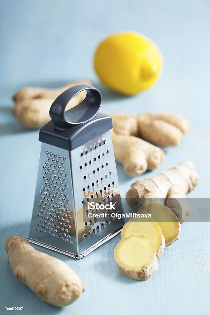 fresh ginger root and grater over blue Asian Culture Stock Photo