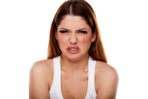 Close-up headshot of senior woman, looking distraught and terrified, with copy space on blue background.