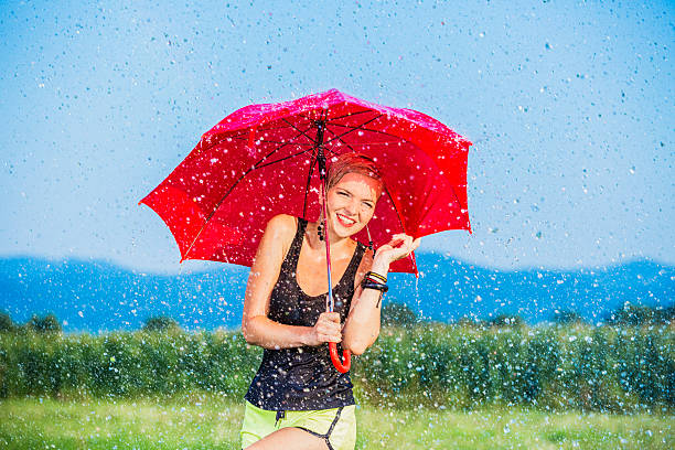 istock Young woman laughing in the summer rain 466611649