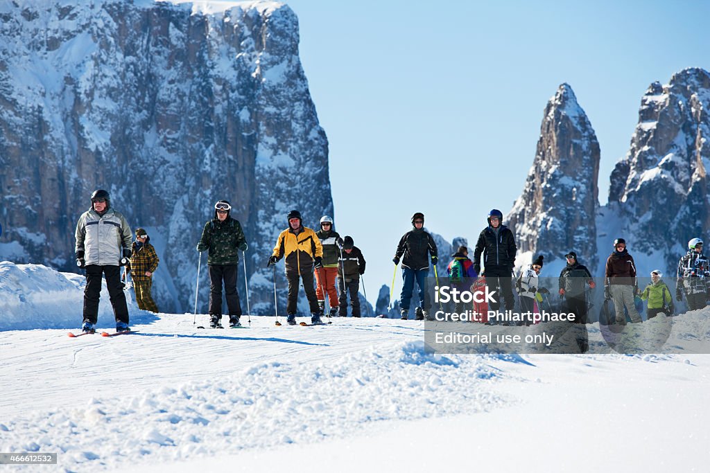 group of winter sports tourists alpine skiing on Seiser Alm Seis, Italy - February 24, 2014: Group of winter sports tourists alpine skiing on Seiser Alm in Italy. The Seiser Alm is a tableland in the Dolomite alps of northern Italy and a popular winter sports location for tourists from all over the world as well as professional athletes. Cross country skiing and downhill skiing are performed by visitors. 2015 Stock Photo