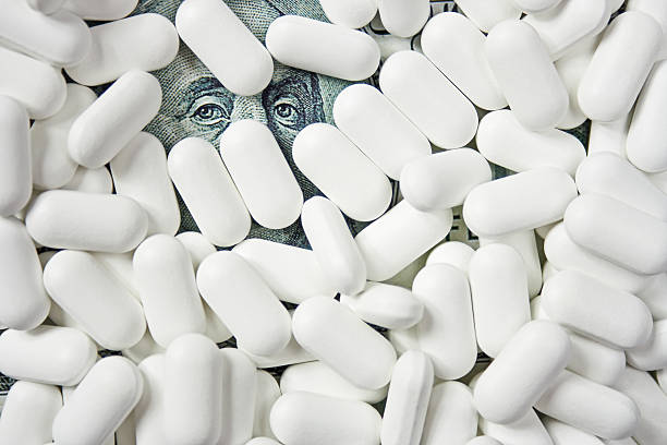 Expensive pills White pill are on the dollar bill big pharma stock pictures, royalty-free photos & images