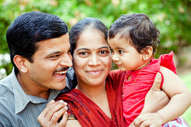 幸せな若い家族の楽しいインドのカップル - offspring family love india ストックフォトと画像