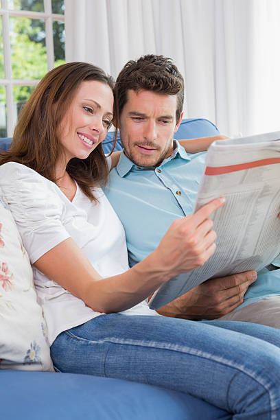 istock Relaxed couple reading newspaper on couch 466616414