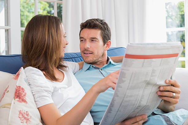 istock Relaxed happy couple reading newspaper on couch 466616514