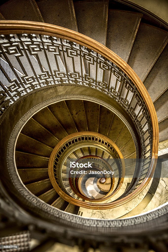 Conical Shaped Old Spiral Staircase Natural light adorns a old-fashioned conical shaped spiral staircase in a historic old San Francisco building. Spiral Staircase Stock Photo