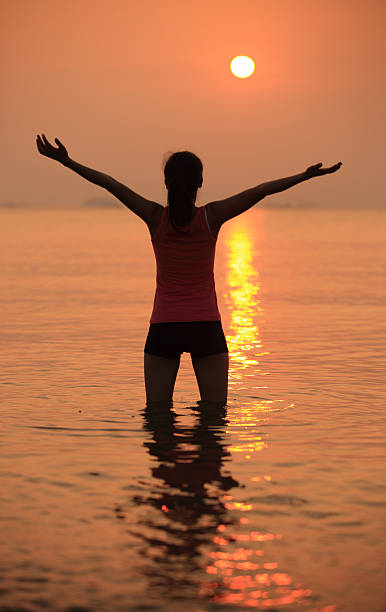 istock cheering  woman seaside sunrise 466620089
