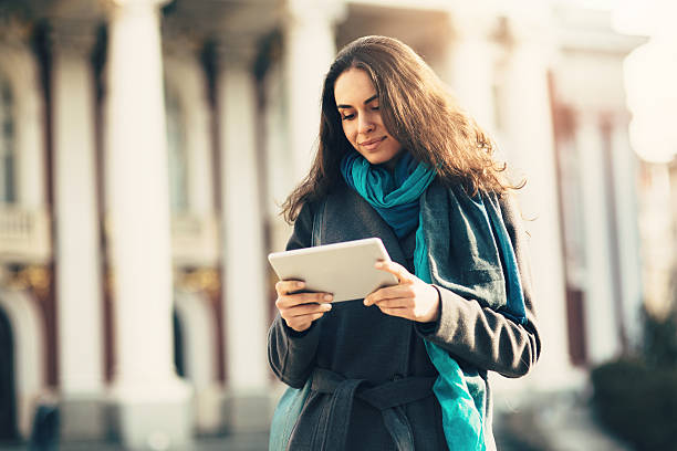 istock Pretty Young Woman using digital tablet outdoors 466625046