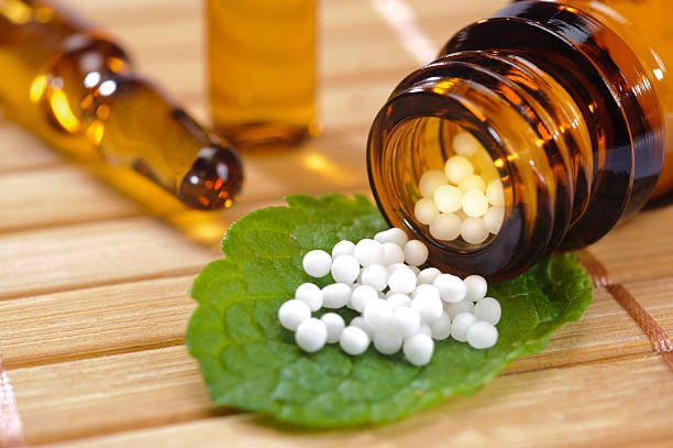 alternative medicine alternative medicine with homeopathy and herbal pills homeopathic medicine photos stock pictures, royalty-free photos & images