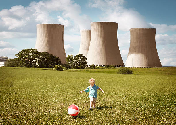 ragazzino giocando vicino alla centrale nucleare - nuclear power station nuclear energy child nuclear reactor foto e immagini stock