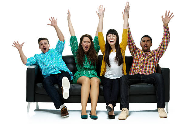 istock Four cheerful people on couch and cheering 466631236