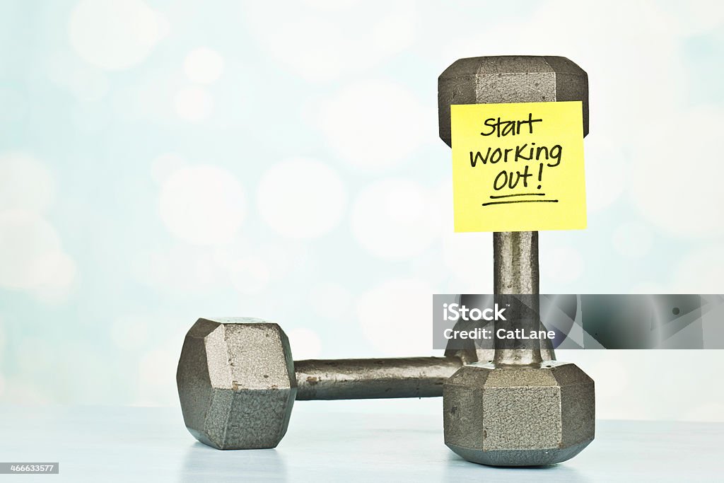 Fitness Message: Start Working Out Dumbbells with reminder note that reads, "start working out!" Adhesive Note Stock Photo