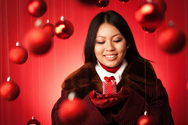 istock Smiling Female Asian Model Offering Christmas Gift Hz 466634035