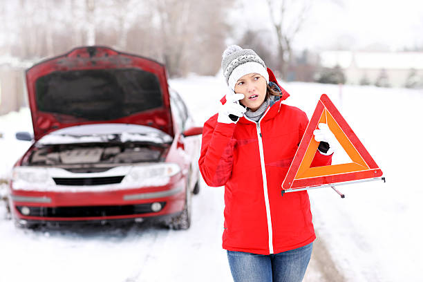 istock Woman reporting a car breakdown in the snow 466636503