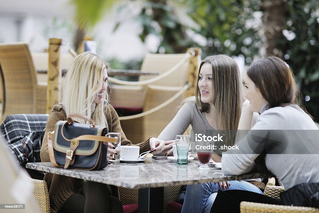 cute smiling women drinking a coffee very cute smiling women drinking a coffee sitting inside in cafe restaurant Adult Stock Photo