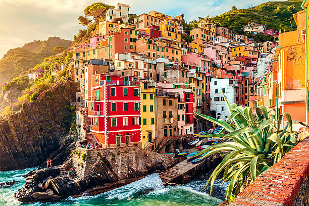 City in Italy with buildings on the coast Riomaggiore at sunset, Cinque Terre National Park, Liguria, La Spezia, Italy liguria photos stock pictures, royalty-free photos & images