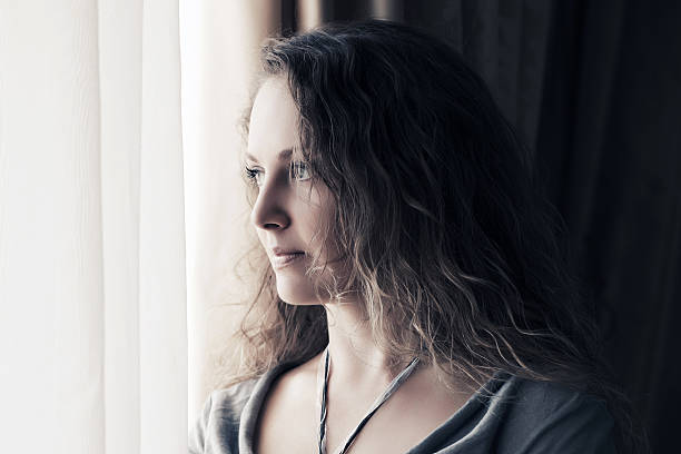istock Sad beautiful woman looking out window 466652118