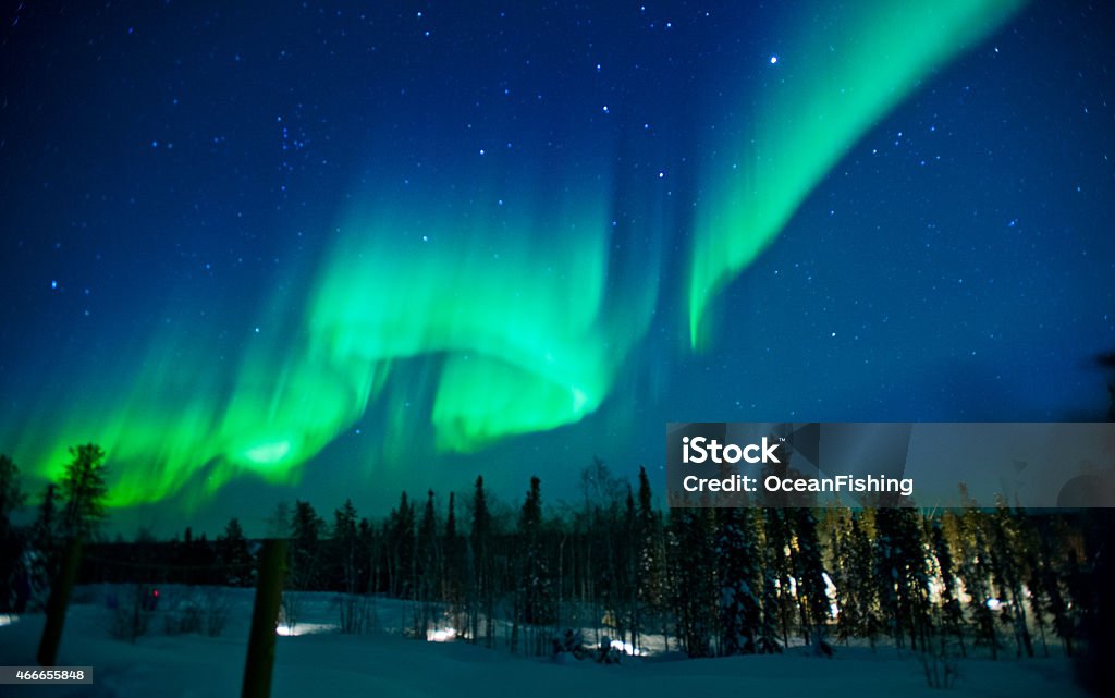 The northern lights across the sky with greens and blues The northern lights stream across the arctic sky near Yellowknife, Northwest Territories in Canada. Aurora Borealis Stock Photo