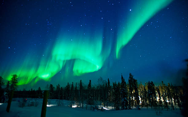 The northern lights across the sky with greens and blues The northern lights stream across the arctic sky near Yellowknife, Northwest Territories in Canada. aurora polaris stock pictures, royalty-free photos & images