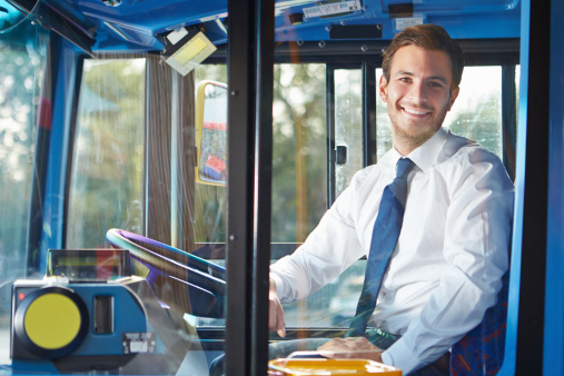 Portrait Of Happy Smiling Male Bus Driver Behind Wheel