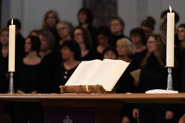Church choir during worship service Ludwigsburg, Germany - March 8, 2015: The church choir The Voices Of Peace perform during the worship service in the Friedenskirche - Peace Church - on March 8, 2015 in Ludwigsburg, Germany. A bible in the foreground is displaying Psalm 69 in German language. ludwigsburg photos stock pictures, royalty-free photos & images