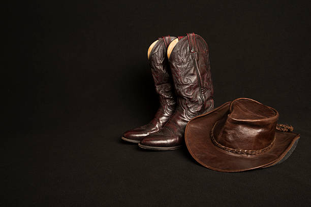 istock Cowboy boots and cowboy hat on black background 466667638
