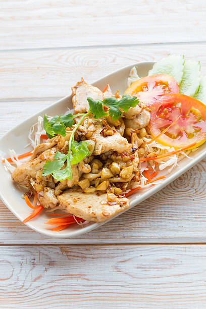 istock Close up stir fried chicken with garlic on wood table 466668016