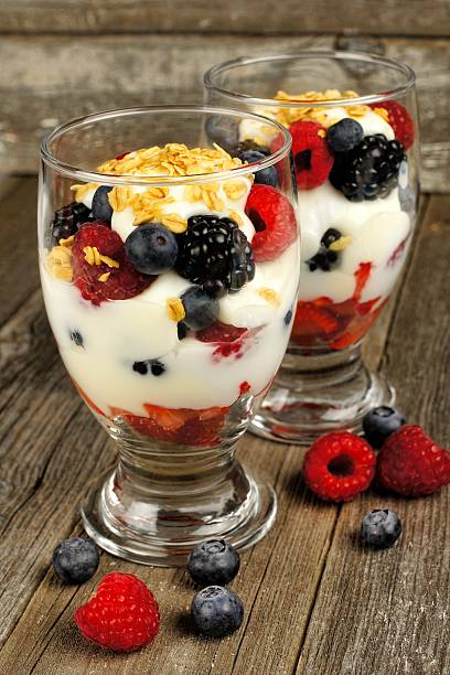 istock Mixed berry granola and yogurt parfaits on wood 466668520