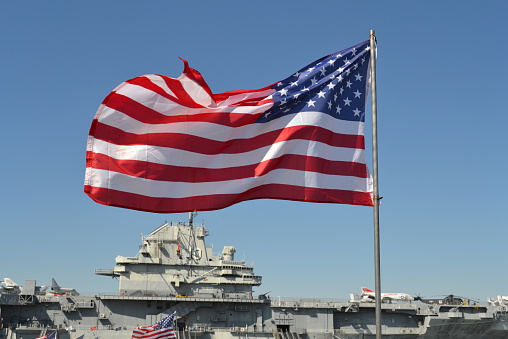 Stars and Stripes in front of USS Yorktown Aircraft Carrier